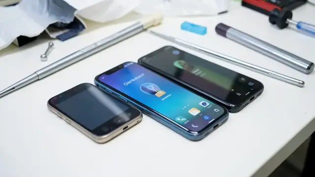 Refurbished smartphones on a workbench with tools