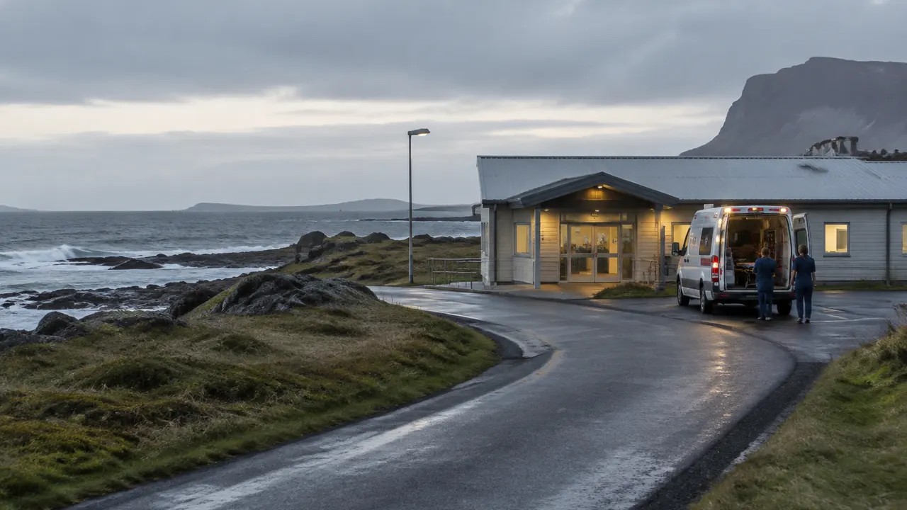 A remote coastal road leads toward a small medical clinic, with an unmarked emergency vehicle parked outside.